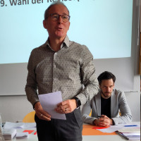 Felix Fröhlich, Vorsitzender der SPD-Kreistagsfraktion, berichtet aus dem Kreistag. Hinter ihm sitzt Bezirks- und Kreisrat Sven Ehrhardt.